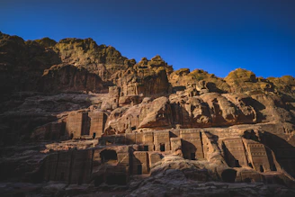 Ancient Mesopotamian cliffside with golden and orange hues under a twilight sky.