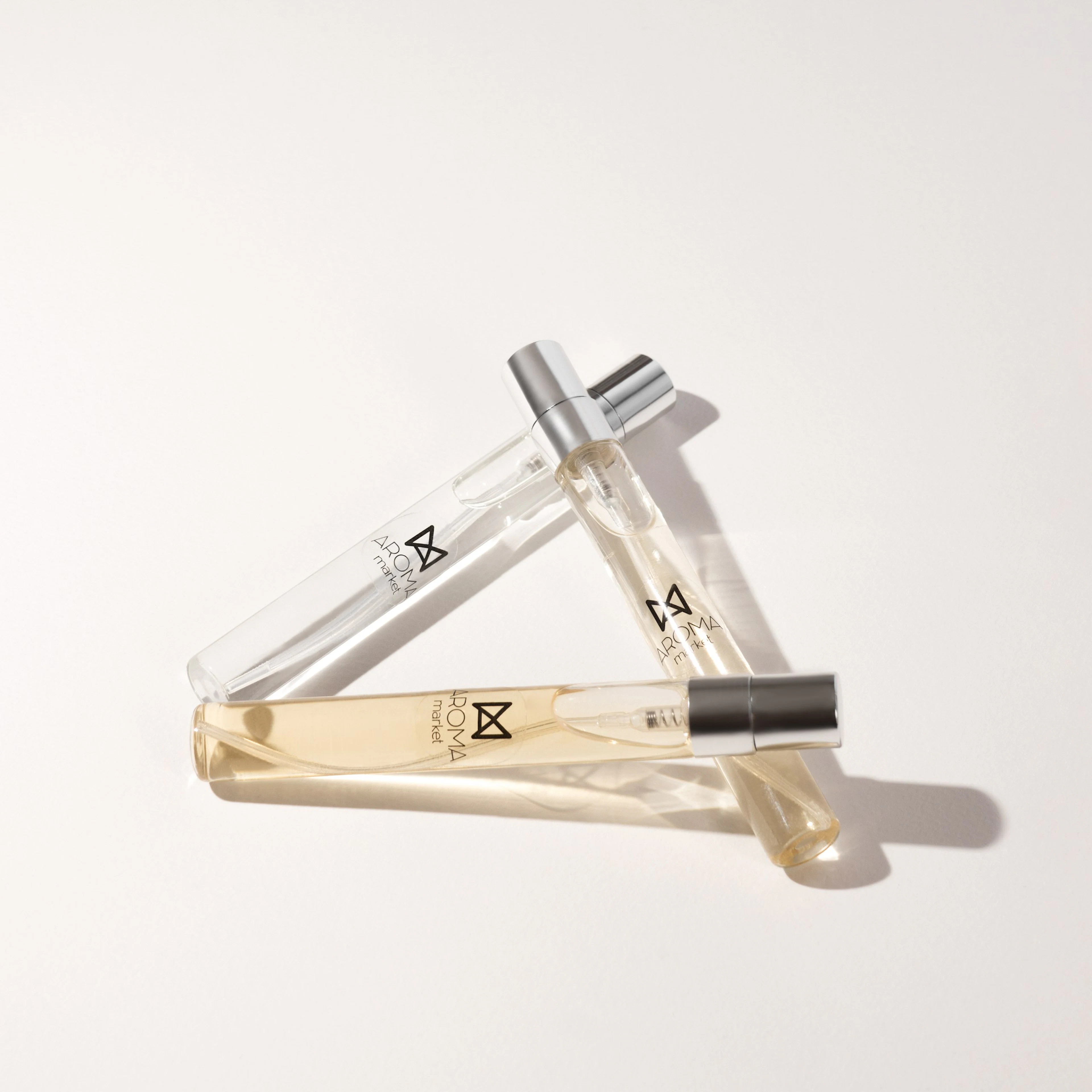 Viales de perfume de 3 ml acomodados sobre fondo claro