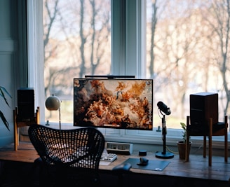 a desk with a monitor and speakers on it
