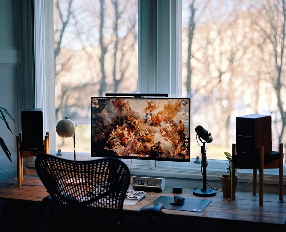 a desk with a monitor and speakers on it