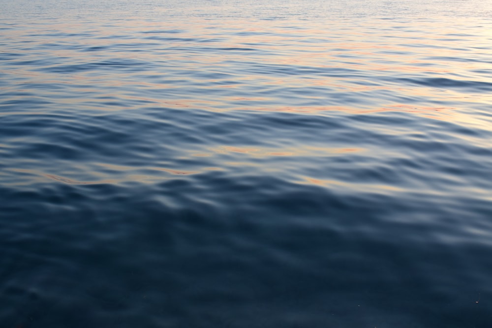 a large body of water with a boat in the distance