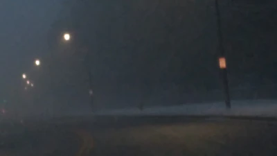 Soft-focus image of a quiet street at dusk with glowing street lamps.