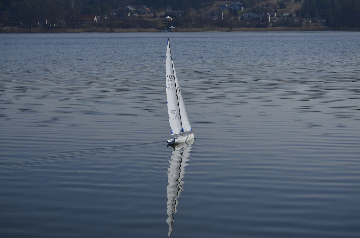 Sailboat on a calm lake in summer