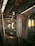 The interior of a modern train or subway car, featuring empty seats lined along the walls. Overhead handrails with handles hang from the ceiling. The ambient lighting casts a warm, welcoming glow over the polished metal surfaces and reflective floors.