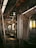 The interior of a modern train or subway car, featuring empty seats lined along the walls. Overhead handrails with handles hang from the ceiling. The ambient lighting casts a warm, welcoming glow over the polished metal surfaces and reflective floors.