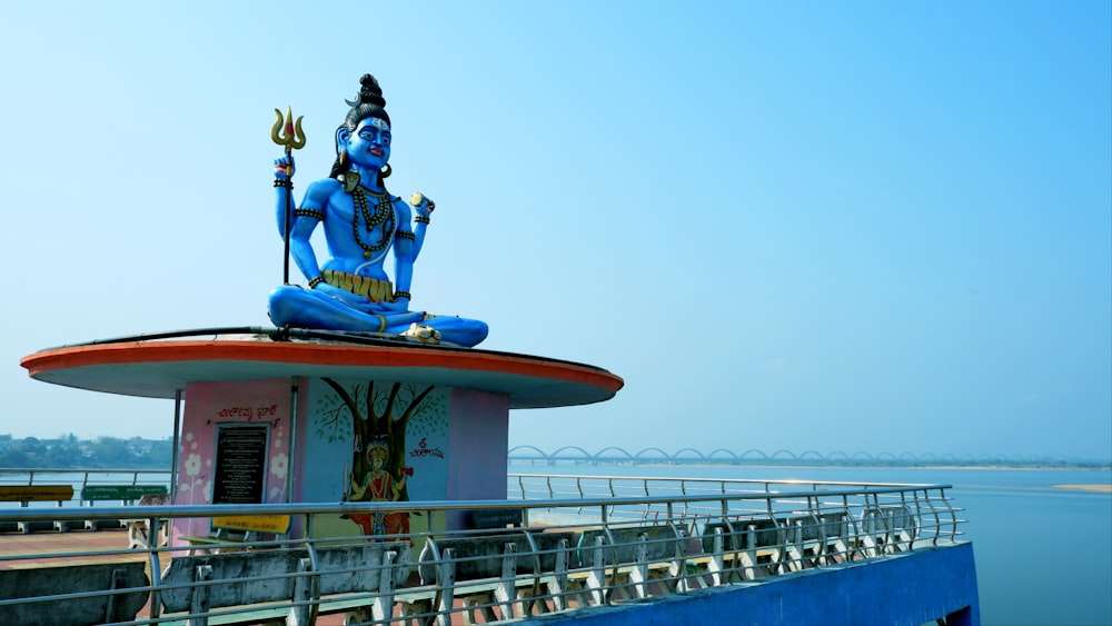 a statue of a person sitting on top of a building