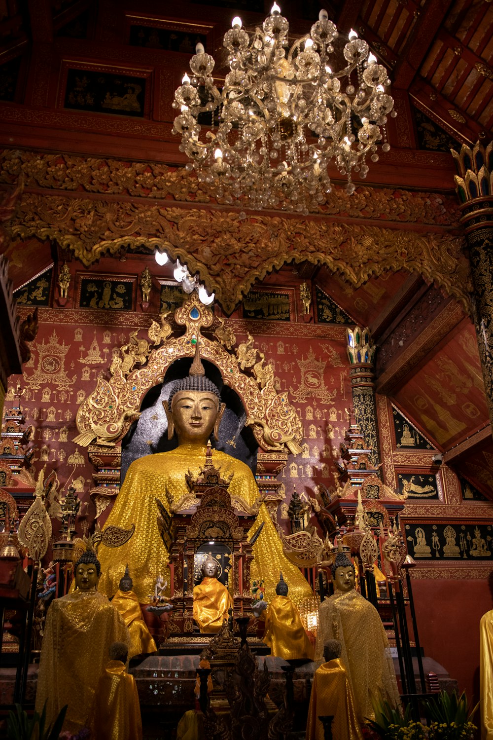 a statue of a buddha in a room with a chandelier