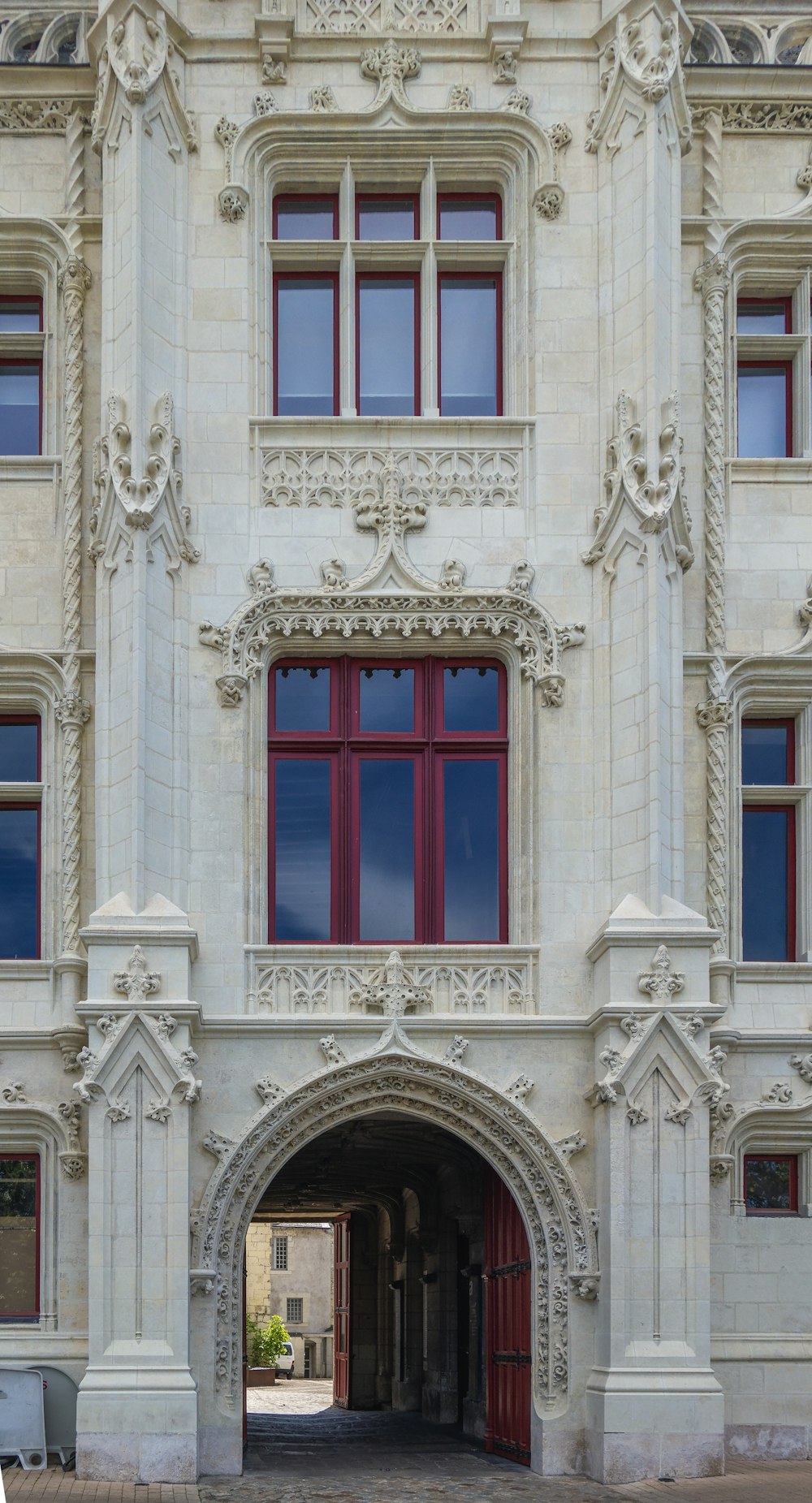 Un grand bâtiment blanc avec une porte rouge