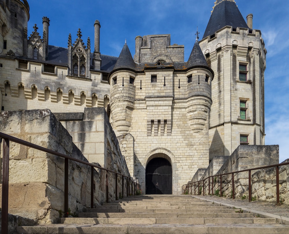 un château en pierre avec des escaliers qui y mènent