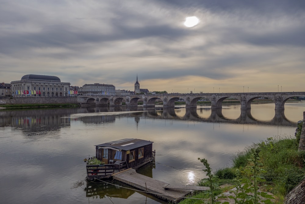 a boat floating on top of a river next to a bridge