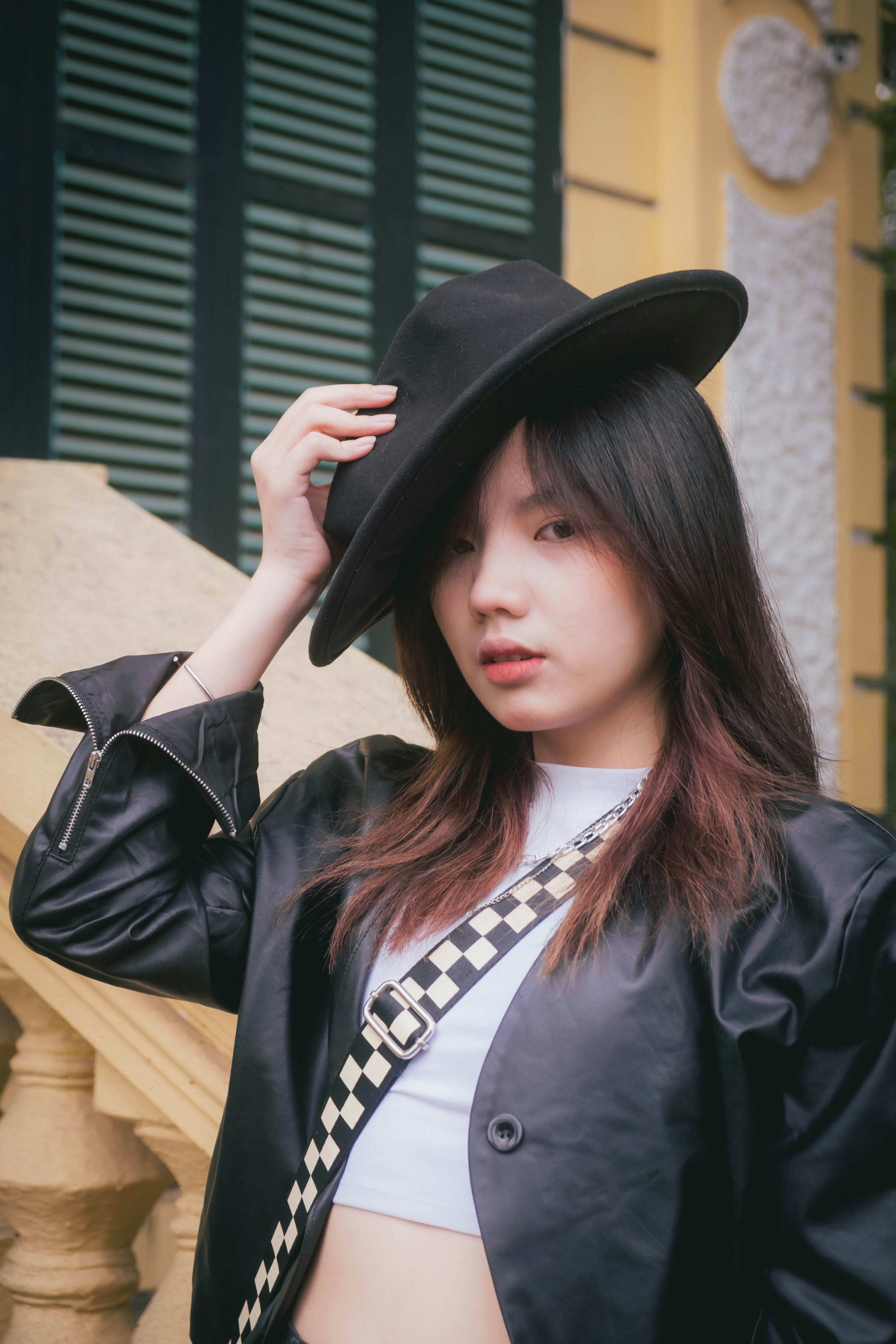 seorang wanita mengenakan topi hitam dan jaket hitam