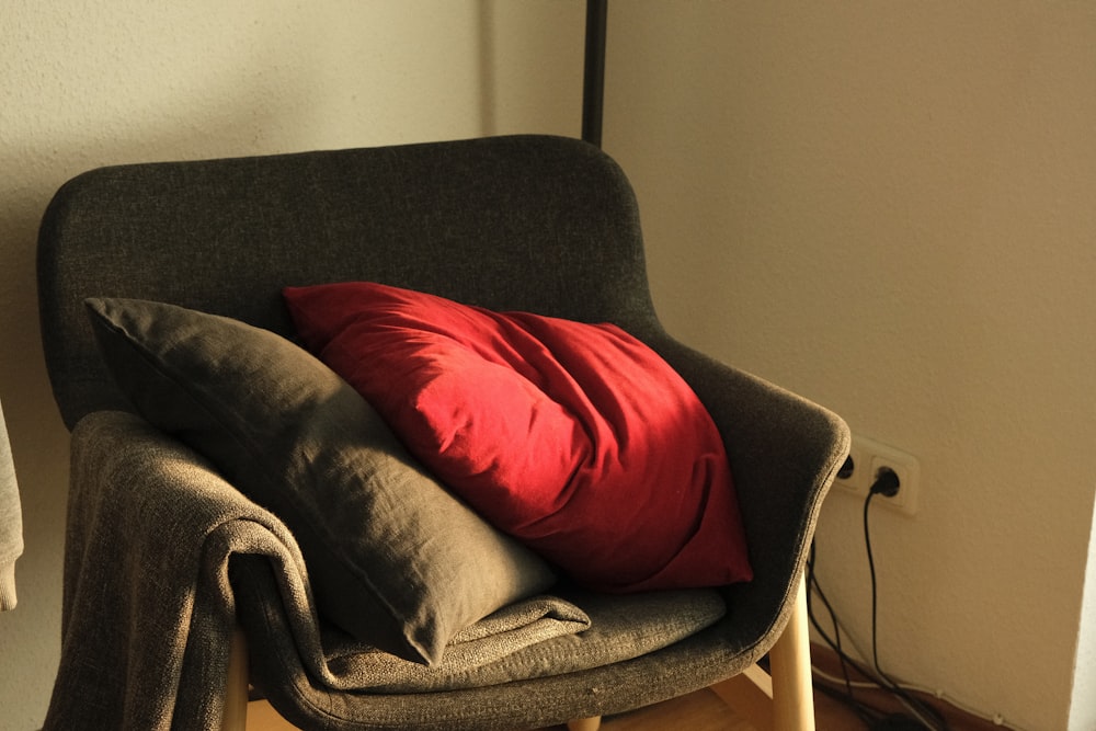 a chair with a red pillow on top of it