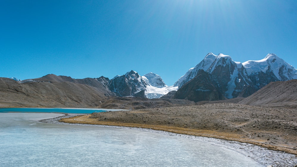 a mountain range with a lake in the foreground