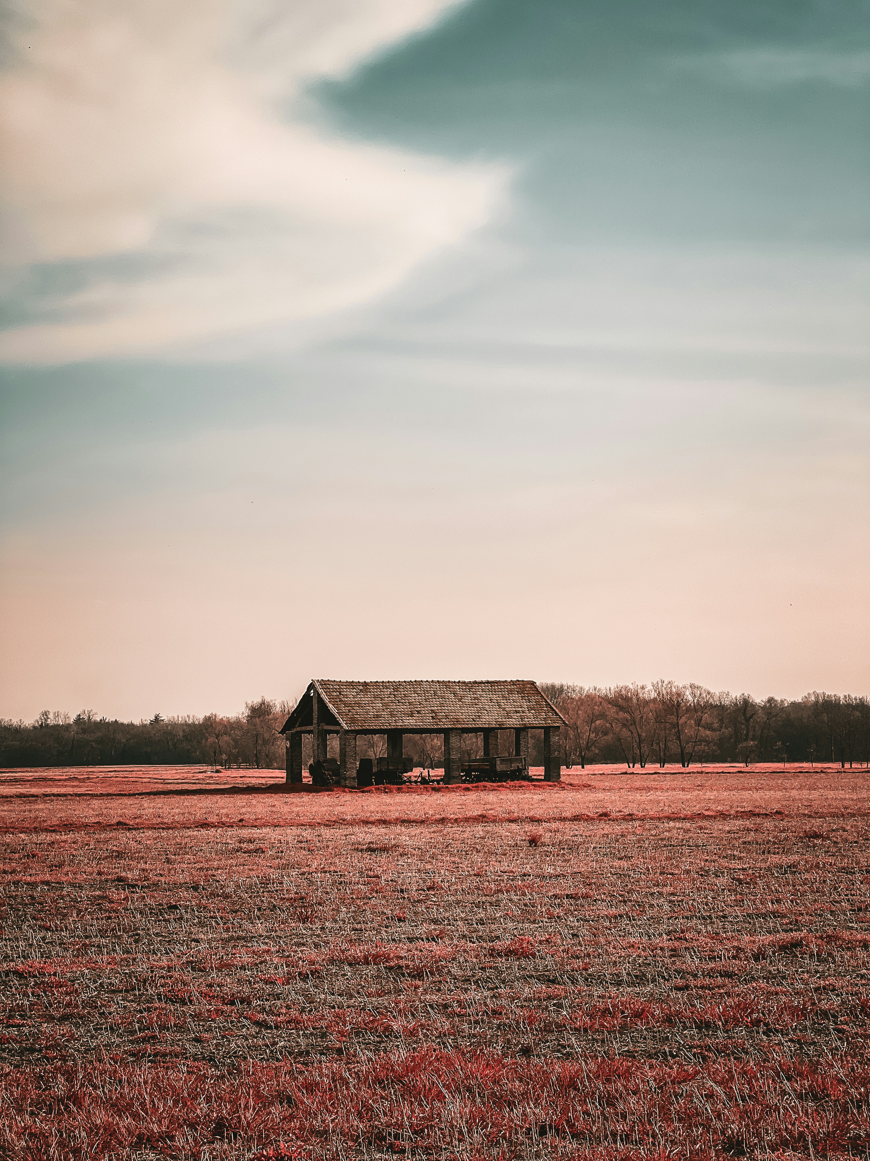 Ein Haus auf einem Feld mit einem Himmel im Hintergrund