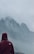 Image of a woman wearing a waterproof jacket, standing in the rain with a mountain backdrop.