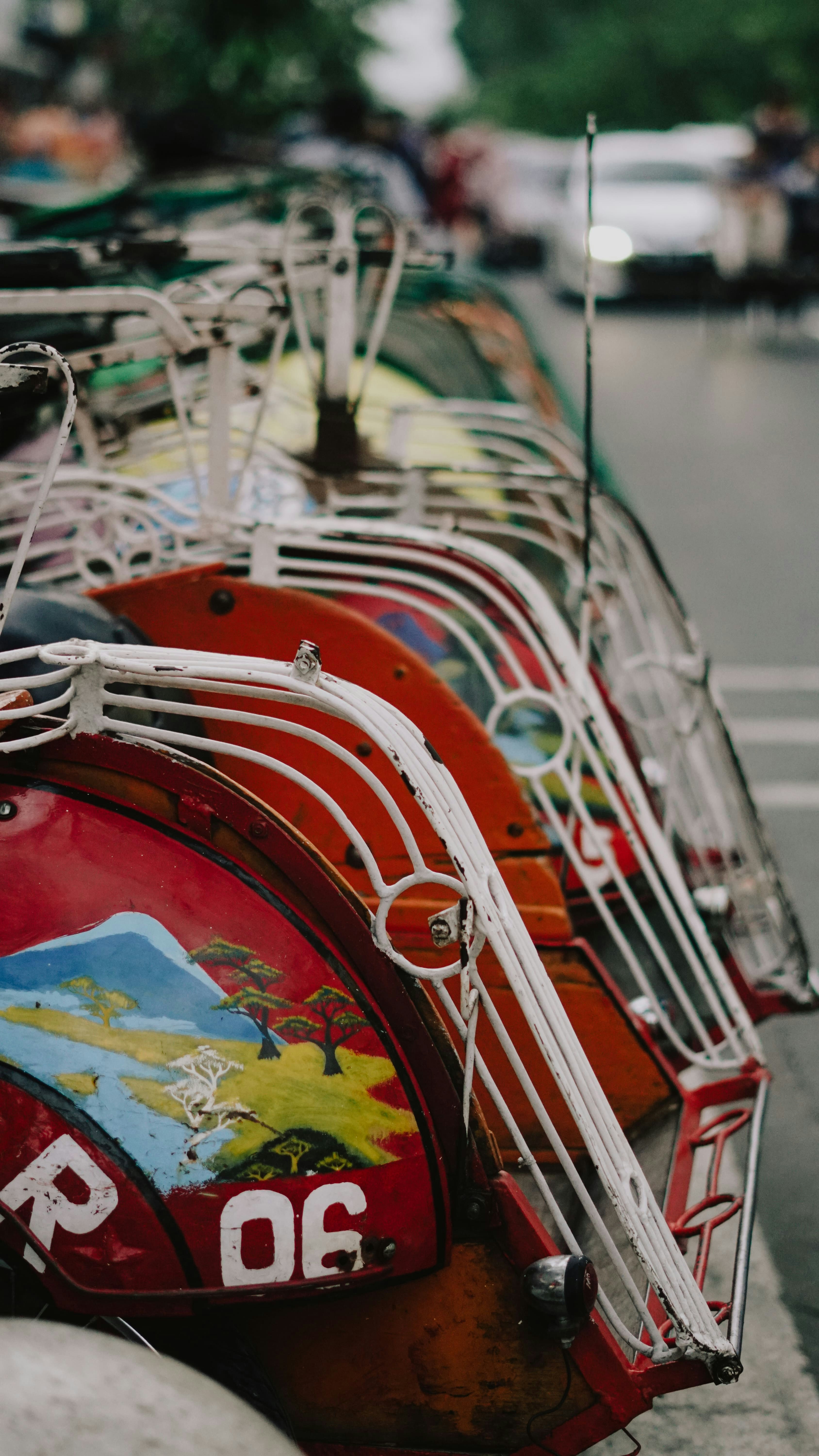 a row of colorfully painted bicycles parked on the side of a road