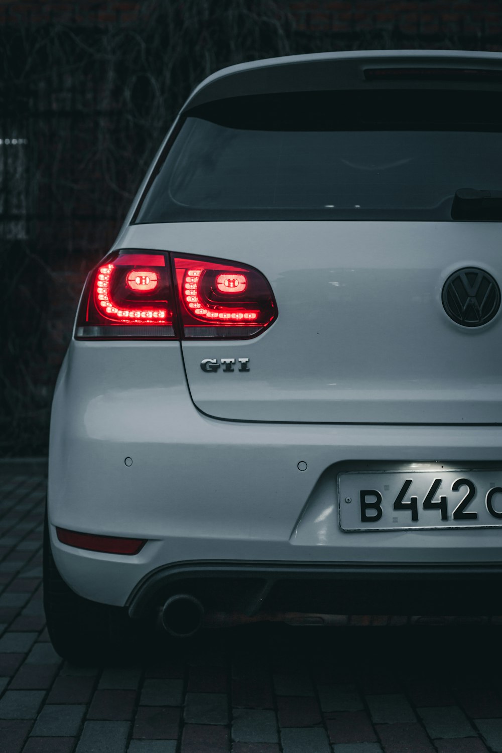 a white volkswagen car parked on a brick road