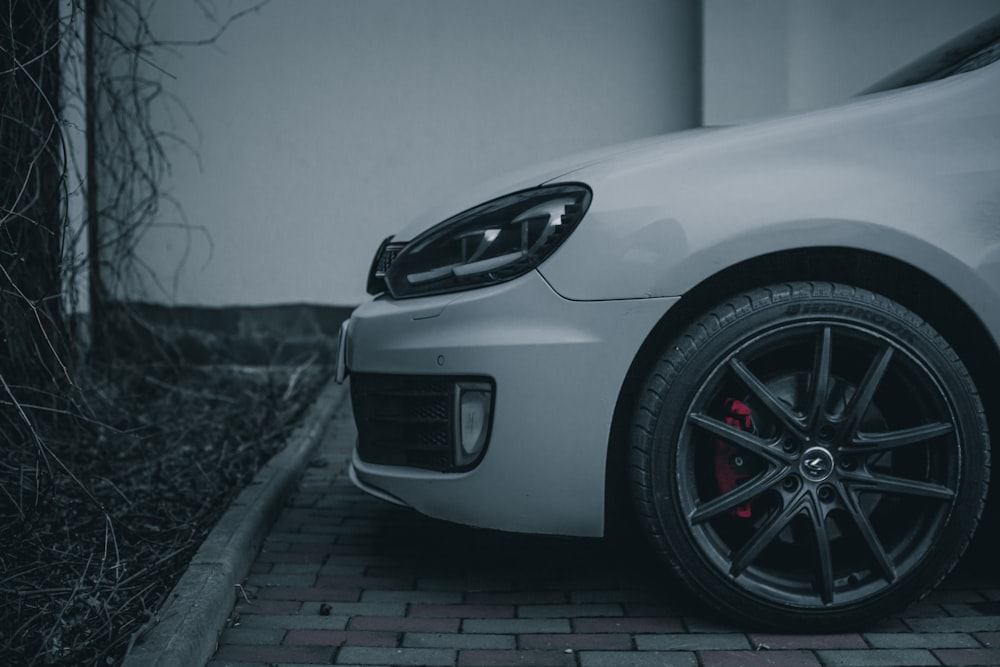 a white car parked on a brick road