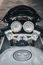 A close-up of a motorcycle dashboard with speedometer and controls.