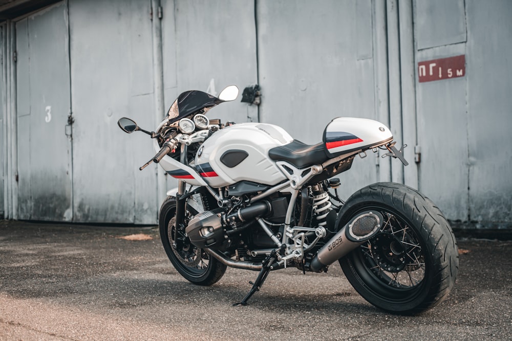 a white and red motorcycle parked in front of a building