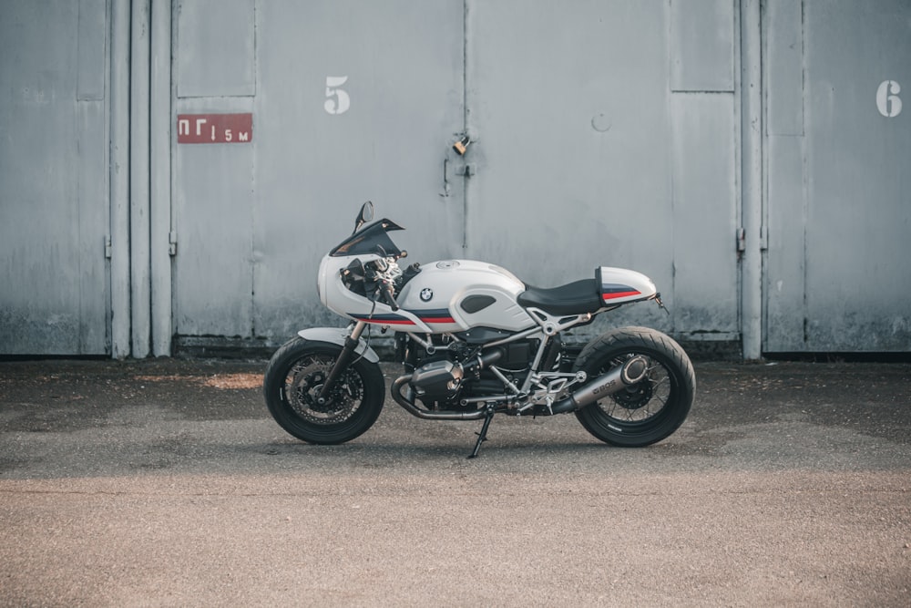 a white and black motorcycle parked in front of a building