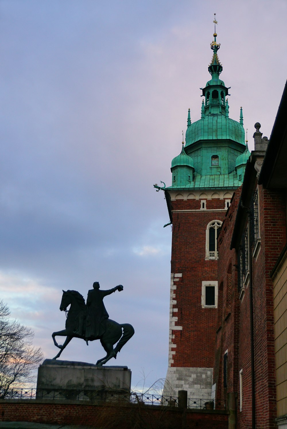 uma estátua de um homem em um cavalo na frente de um edifício