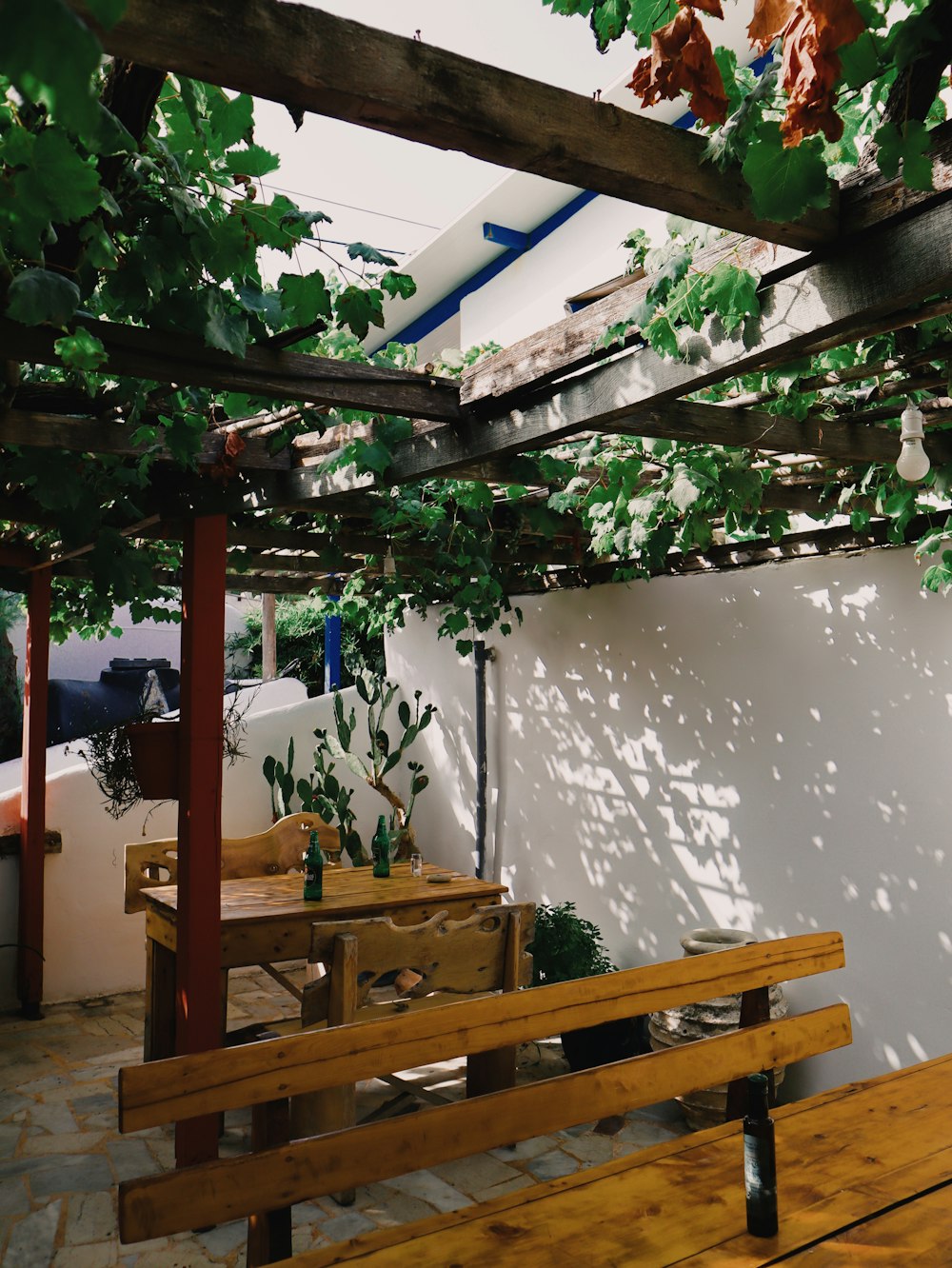 a wooden bench sitting under a pergolated roof