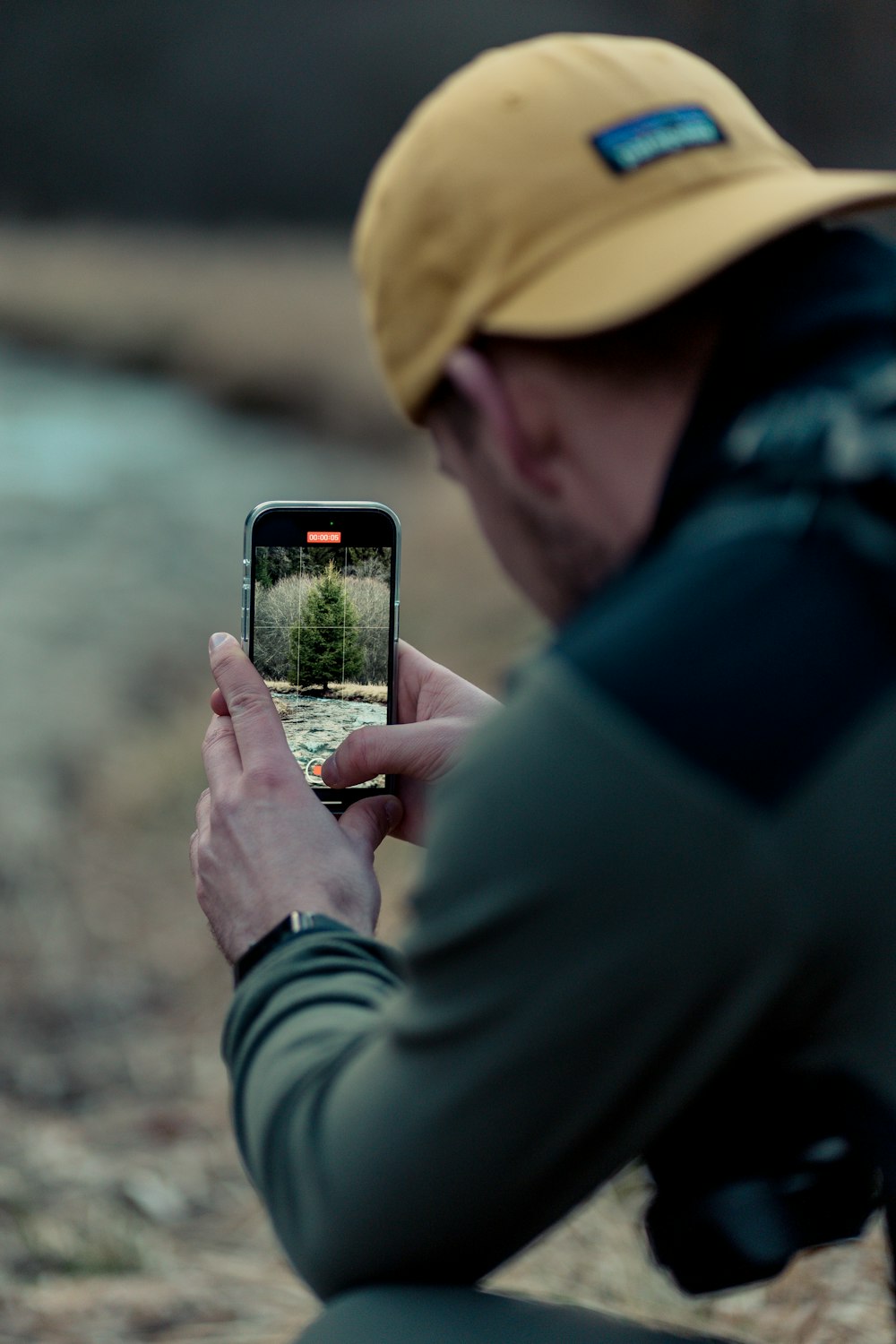 a man taking a picture of a small tree