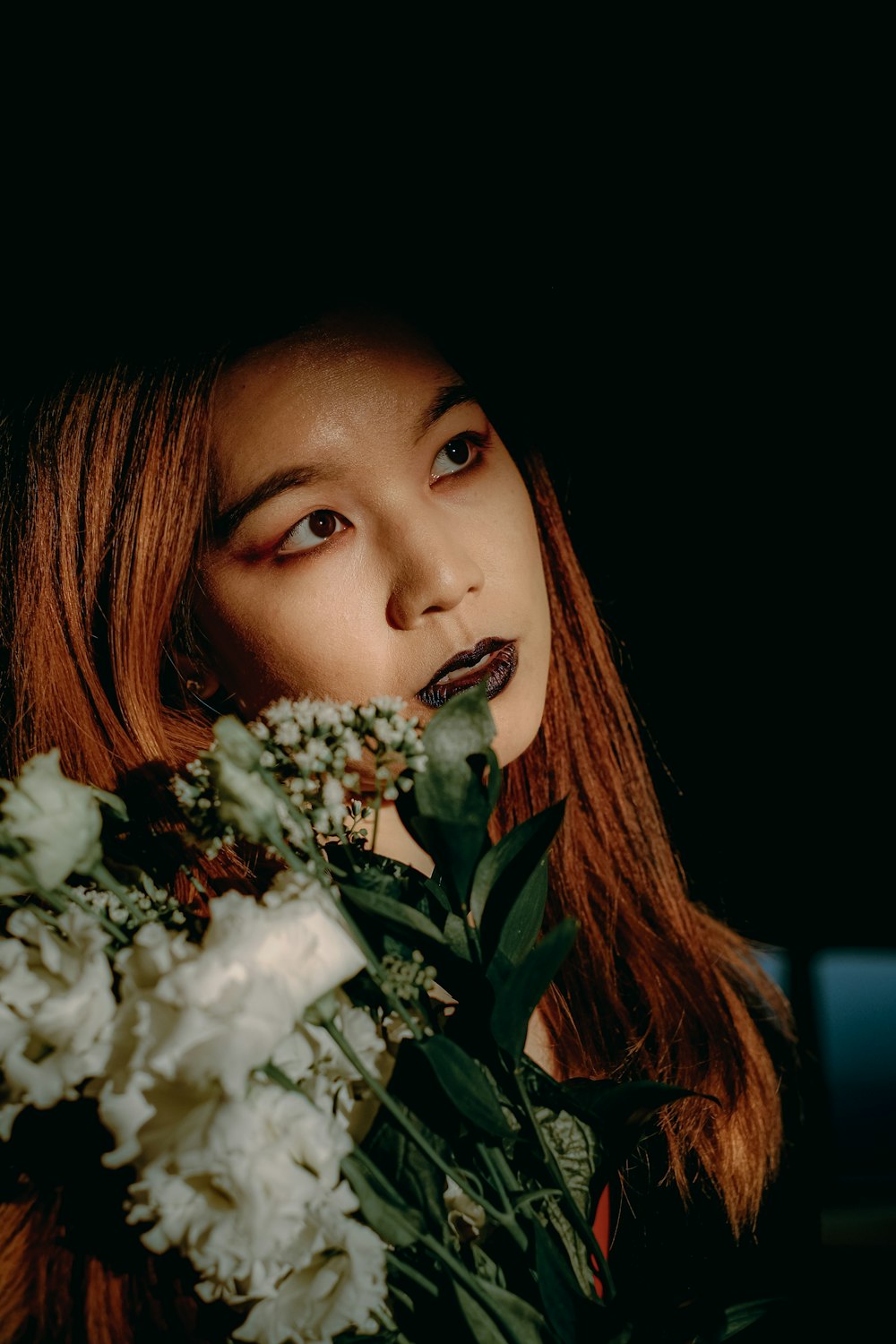 a woman holding a bouquet of flowers in front of her face