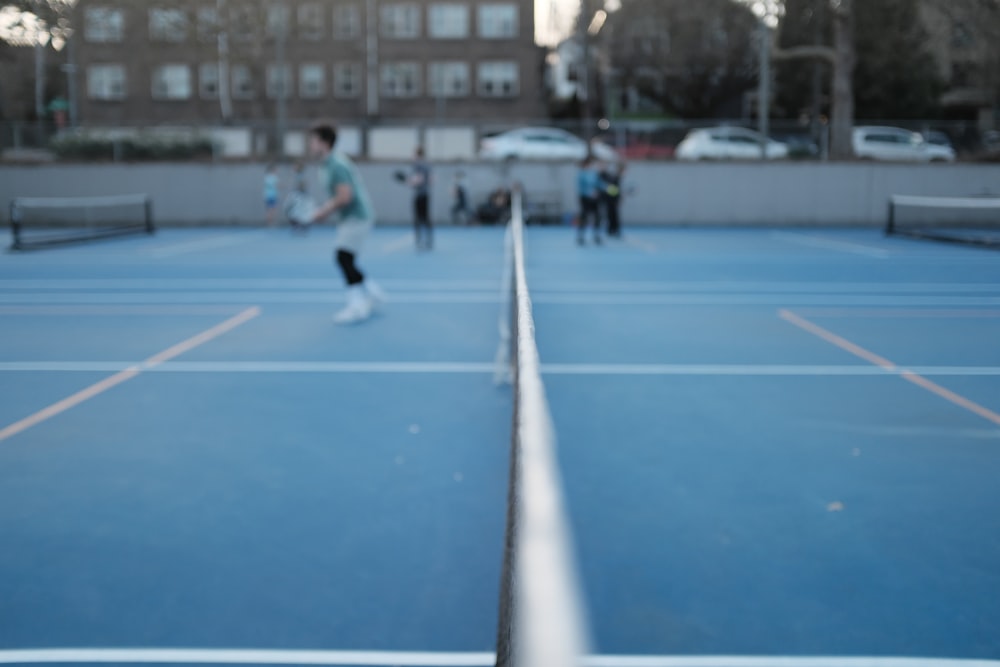 a group of people standing on top of a tennis court