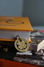 Close-up of a delicate acrylic flower pendant resting on a soft leather cord beside a handcrafted ocean-themed bookend.