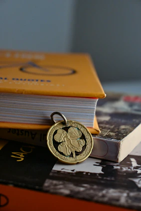 Close-up of a delicate acrylic flower pendant resting on a soft leather cord beside a handcrafted ocean-themed bookend.
