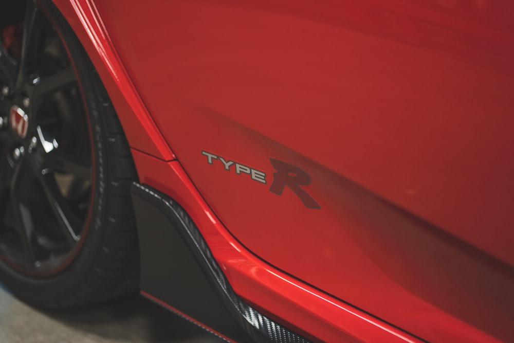 a close up of the side of a red sports car