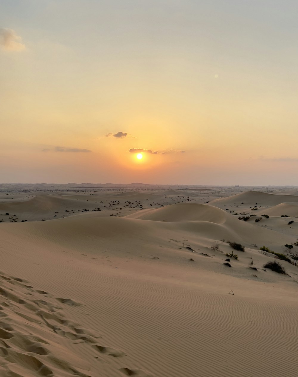 Il sole sta tramontando sulle dune di sabbia