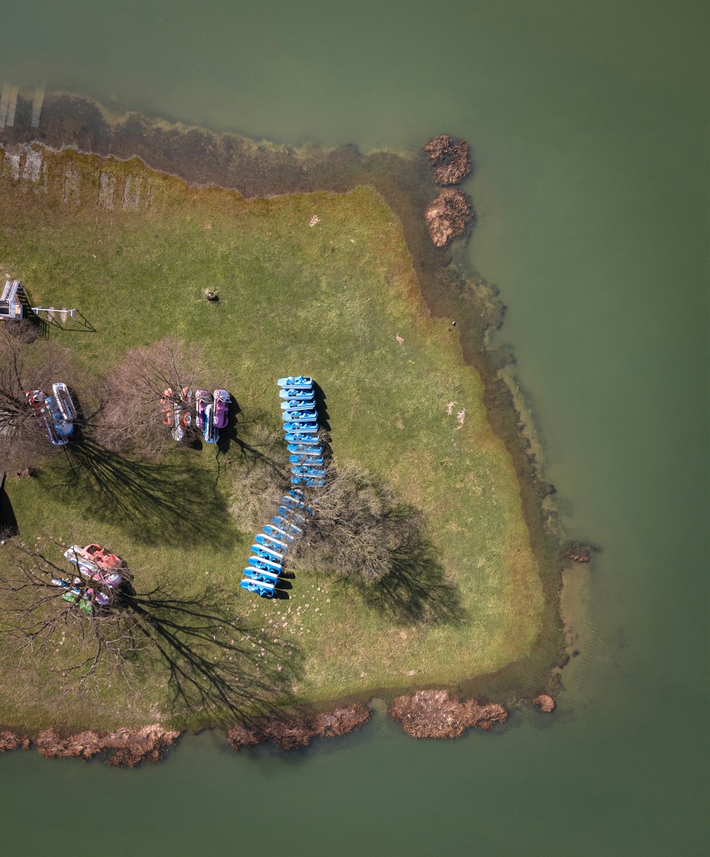 an aerial view of a grassy area with several blue canoes