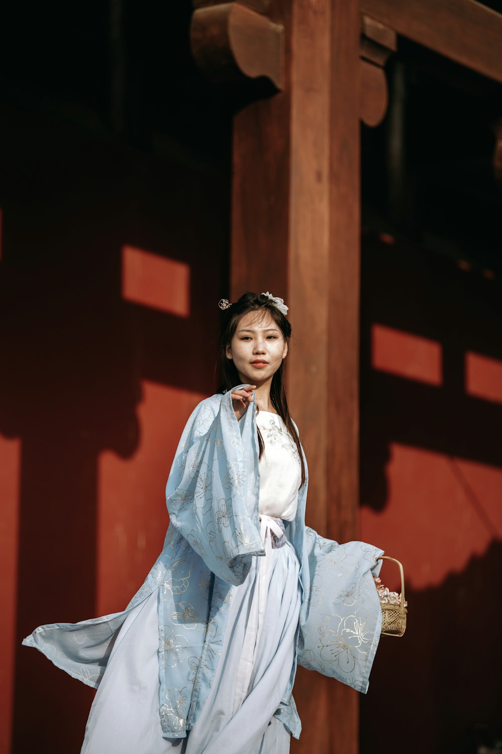 a woman in a blue kimono holding a basket