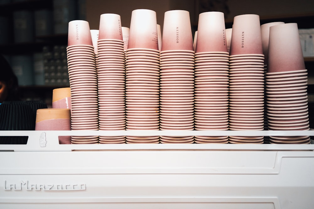 a stack of pink cups sitting on top of a counter