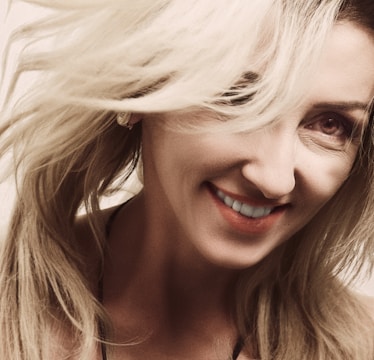 Close-up of a woman smiling with thick, natural-looking hair seamlessly blended.