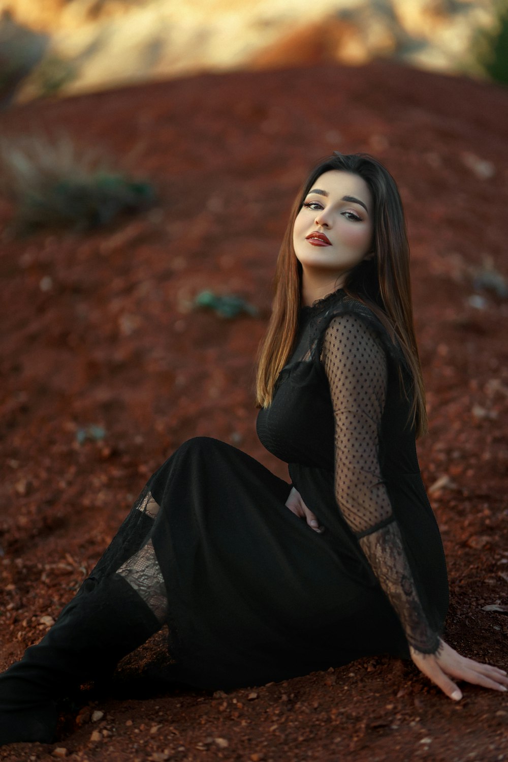 a woman in a black dress sitting on the ground