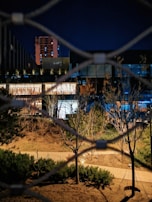 Nighttime view of a security patrol walking along a fenced perimeter.