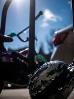Close-up of a vibrant red helmet resting on a wooden bench under sunlight