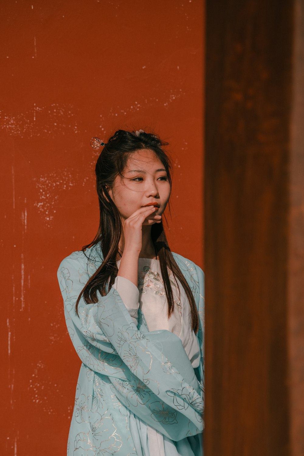 a woman standing in front of a red wall