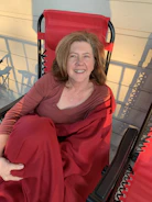 Carol in her safe new home, surrounded by donated furniture and warmth.