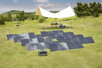 A group of students gathered around a solar panel installation, hands-on training under a bright African sky.
