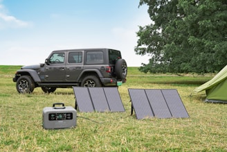 a jeep is parked next to a solar panel