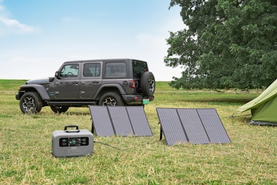 a jeep is parked next to a solar panel