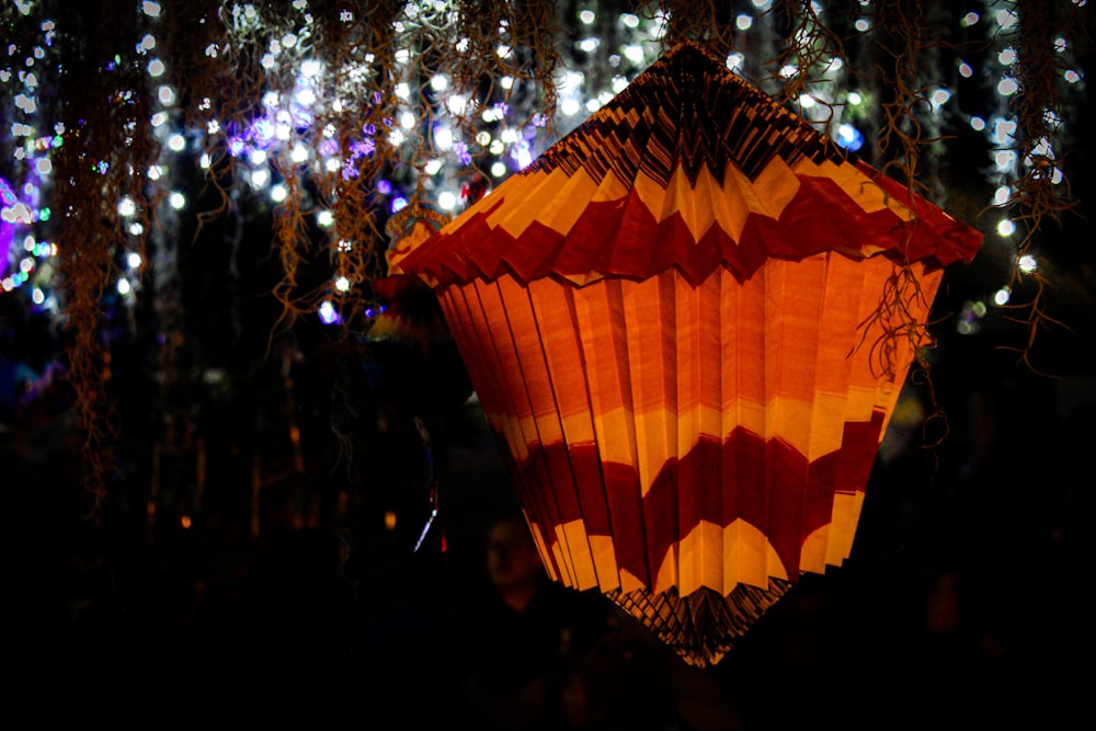 a red and yellow lantern hanging from a tree