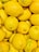 Close-up of bright yellow organic lemons freshly delivered in a rustic wooden crate.