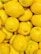 Close-up of bright yellow organic lemons freshly delivered in a rustic wooden crate.