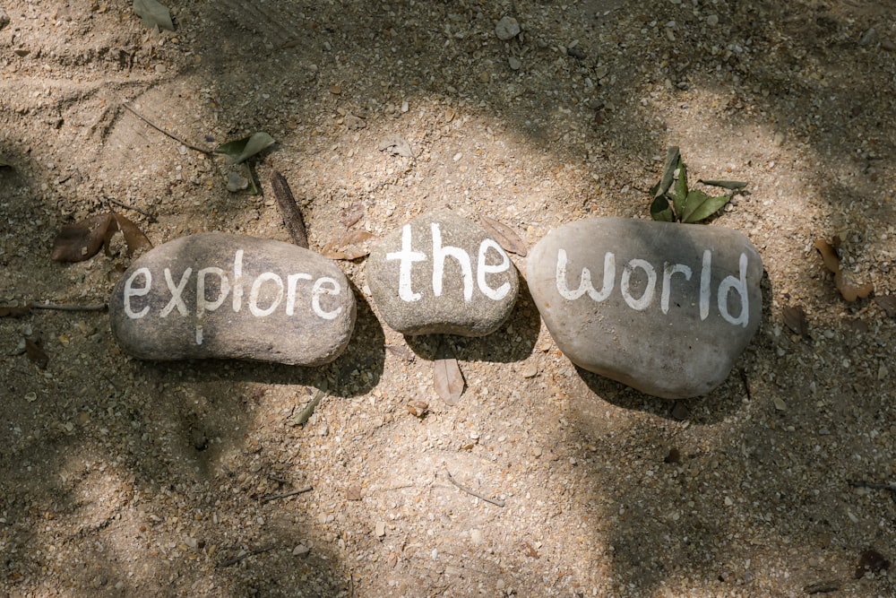 Dos rocas con las palabras exploran el mundo escritas en ellas
